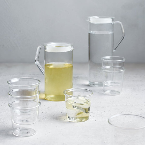 Kinto 41 oz CAST water jugs and some glasses on a table.