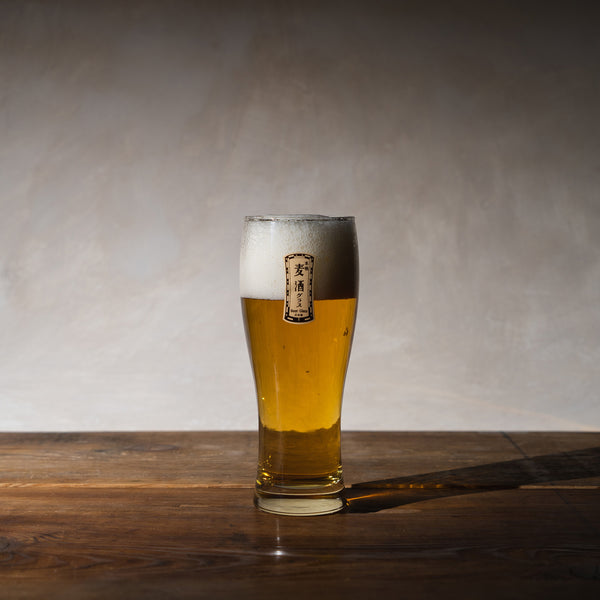 A beer glass with beer on it on a wooden table