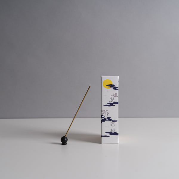 Moon Rabbit incense box with blue illustrations of rabbits and a yellow moon, accompanied by a single incense stick on a gray background.