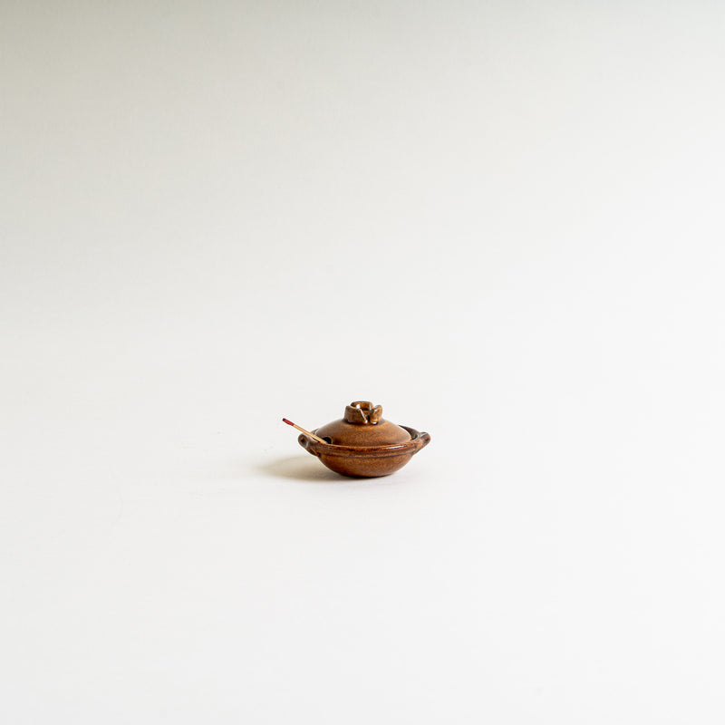 A brown mini donabe shape condiment container
