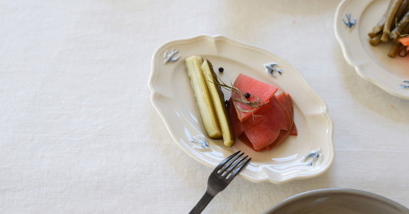 Pickles on a 7.5" Stduio M' early bird oval plate on a white table 