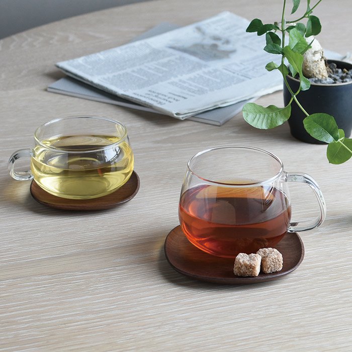 Two glass teacups on two Kinto 4" UNITEA Costers in Walnut
