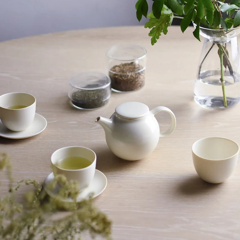 Kinto Pebble Teapot, Teacup & Saucer Set on a wooden table